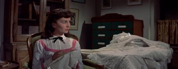 Movie still from “Désirée” (1954), directed by Henry Koster – A woman holding a cane in a room; Medium shot, High angle