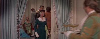 Movie still from “Désirée” (1954), directed by Henry Koster – A woman in a green dress standing in front of a wall; Medium shot, Over the shoulder angle
