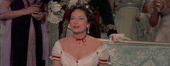 Movie still from “Désirée” (1954), directed by Henry Koster – A woman in a white dress and red ribbon; Close Up shot, Over the shoulder angle