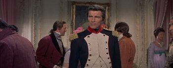 Movie still from “Désirée” (1954), directed by Henry Koster – A man in a military uniform standing in front of a painting; Medium shot, High angle