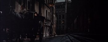 Movie still from “Désirée” (1954), directed by Henry Koster – A dark city street with buildings lit up at night; Wide shot, High angle