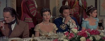 Movie still from “Désirée” (1954), directed by Henry Koster – A man and a woman sitting at a dinner table; Medium shot, Over the shoulder angle