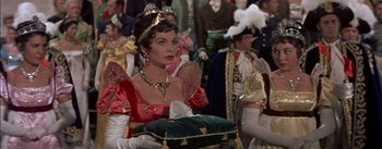 Movie still from “Désirée” (1954), directed by Henry Koster – A woman dressed as a princess in a crowd of people; Medium shot, Over the shoulder angle