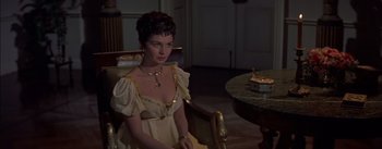 Movie still from “Désirée” (1954), directed by Henry Koster – A woman sitting in front of a table in a living room; Medium shot, High angle