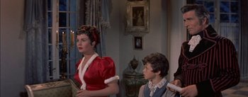 Movie still from “Désirée” (1954), directed by Henry Koster – A woman and a boy are standing in a living room; Medium shot, Over the shoulder angle