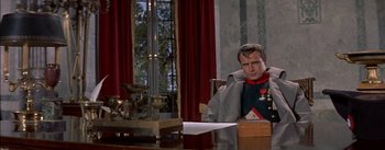 Movie still from “Désirée” (1954), directed by Henry Koster – A man sitting at a table in front of a window; Medium shot, Over the shoulder angle