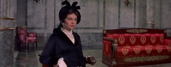 Movie still from “Désirée” (1954), directed by Henry Koster – A woman wearing a black dress and a black hat; Medium shot, High angle