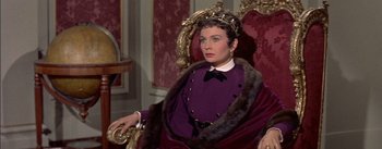 Movie still from “Désirée” (1954), directed by Henry Koster – A woman sitting in a chair wearing a purple dress; Medium shot, Low angle