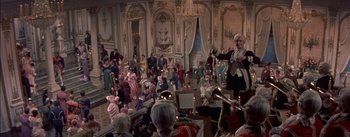 Movie still from “Désirée” (1954), directed by Henry Koster – An audience of people dressed in period costumes and playing musical instruments; Wide shot, High angle