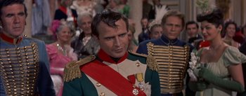 Movie still from “Désirée” (1954), directed by Henry Koster – A person wearing a suit and tie; Close Up shot, Over the shoulder angle