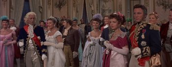 Movie still from “Désirée” (1954), directed by Henry Koster – A group of people dressed in period costumes; Medium shot, Over the shoulder angle