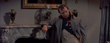 Movie still from “Désirée” (1954), directed by Henry Koster – A man sitting in front of an ornate clock; Medium shot, High angle