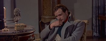 Movie still from “Désirée” (1954), directed by Henry Koster – A man in a gray coat sitting in front of a table; Close Up shot, Low angle