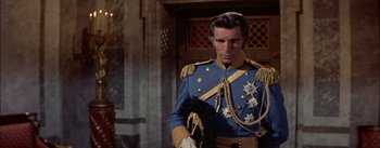 Movie still from “Désirée” (1954), directed by Henry Koster – A man in a blue and gold uniform holding a black dog; Medium shot, Over the shoulder angle