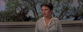 Movie still from “Désirée” (1954), directed by Henry Koster – A woman in a white shirt and a pearl necklace; Close Up shot, Over the shoulder angle