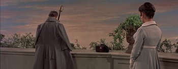 Movie still from “Désirée” (1954), directed by Henry Koster – A man standing on top of a building next to bushes; Wide shot, Low angle