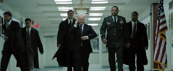 Movie still from “Eagle Eye” (2008), directed by D.J. Caruso – A group of men walking down a hall way; Medium shot, Low angle