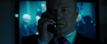 Movie still from “Eagle Eye” (2008), directed by D.J. Caruso – A man in a suit and tie talking on a cell phone; Close Up shot, Low angle