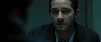 Movie still from “Eagle Eye” (2008), directed by D.J. Caruso – A person wearing a suit and tie; Close Up shot, Over the shoulder angle