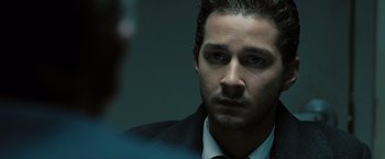 Movie still from “Eagle Eye” (2008), directed by D.J. Caruso – A person wearing a suit and tie; Close Up shot, Over the shoulder angle