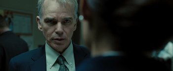 Movie still from “Eagle Eye” (2008), directed by D.J. Caruso – A man in a suit looking at himself in the mirror; Close Up shot, Over the shoulder angle