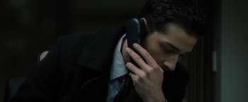 Movie still from “Eagle Eye” (2008), directed by D.J. Caruso – A man in a black jacket is talking on a cell phone; Close Up shot, High angle