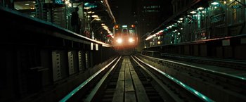 Movie still from “Eagle Eye” (2008), directed by D.J. Caruso – A train is traveling down the tracks at night; Extreme Wide shot, High angle