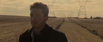 Movie still from “Eagle Eye” (2008), directed by D.J. Caruso – A person standing in a dirt field; Close Up shot, High angle