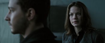 Movie still from “Eagle Eye” (2008), directed by D.J. Caruso – A woman sitting next to a man in a dark room; Close Up shot, Over the shoulder angle