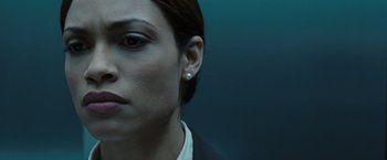 Movie still from “Eagle Eye” (2008), directed by D.J. Caruso – A person wearing a suit and earring; Close Up shot, Over the shoulder angle