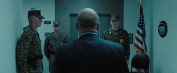 Movie still from “Eagle Eye” (2008), directed by D.J. Caruso – A group of men standing next to each other in front of a door; Medium shot, Over the shoulder angle