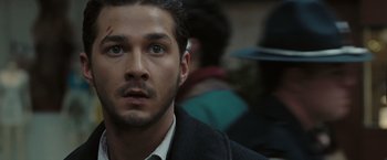 Movie still from “Eagle Eye” (2008), directed by D.J. Caruso – A person wearing a suit and tie; Close Up shot, Over the shoulder angle