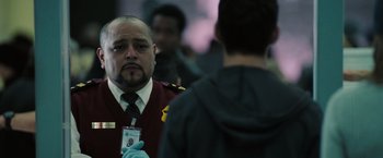 Movie still from “Eagle Eye” (2008), directed by D.J. Caruso – A man in a red jacket is holding a badge; Close Up shot, Low angle