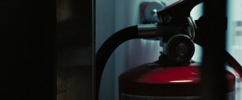 Movie still from “Eagle Eye” (2008), directed by D.J. Caruso – A fire extinguisher is shown next to a wall; Extreme Close Up shot, Low angle