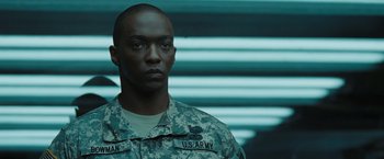 Movie still from “Eagle Eye” (2008), directed by D.J. Caruso – A man in military fatigues standing in front of a wall; Close Up shot, Low angle