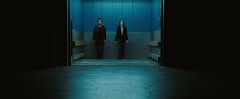 Movie still from “Eagle Eye” (2008), directed by D.J. Caruso – A man and a woman are standing in an elevator; Wide shot, Low angle