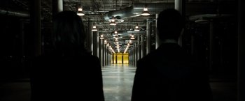 Movie still from “Eagle Eye” (2008), directed by D.J. Caruso – Two people are standing in an industrial hallway; Extreme Wide shot, Low angle
