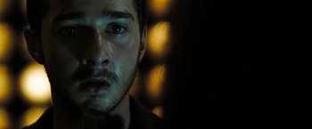 Movie still from “Eagle Eye” (2008), directed by D.J. Caruso – A person's face with lights in the background; Close Up shot, Over the shoulder angle