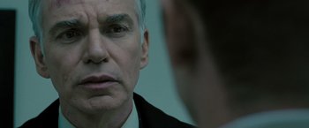 Movie still from “Eagle Eye” (2008), directed by D.J. Caruso – An older man looking at himself in the mirror; Close Up shot, Over the shoulder angle
