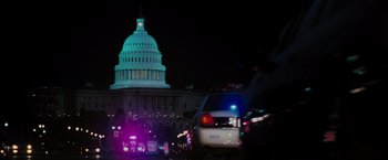 Movie still from “Eagle Eye” (2008), directed by D.J. Caruso – A view of the us capitol at night with cars parked on the side of the street; Extreme Wide shot, Low angle