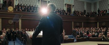 Movie still from “Eagle Eye” (2008), directed by D.J. Caruso – A man standing in front of an audience in front of a crowd; Medium shot, Low angle