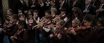 Movie still from “Eagle Eye” (2008), directed by D.J. Caruso – A group of young people playing musical instruments in front of an audience; Medium shot, High angle