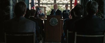 Movie still from “Eagle Eye” (2008), directed by D.J. Caruso – A man and two women are standing in front of a podium; Wide shot, Over the shoulder angle
