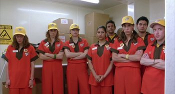 Movie still from “Eagle vs Shark” (2007), directed by Taika Waititi – A group of people standing next to each other; Medium shot, Low angle