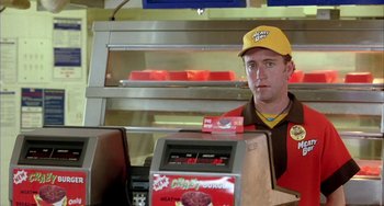 Movie still from “Eagle vs Shark” (2007), directed by Taika Waititi – A man sitting in front of an order counter; Close Up shot, Low angle