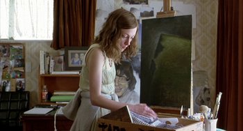 Movie still from “Eagle vs Shark” (2007), directed by Taika Waititi – A woman is painting a portrait of a man; Medium shot, Low angle