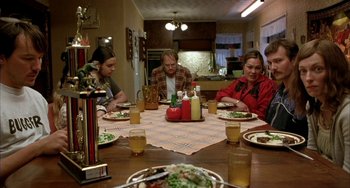 Movie still from “Eagle vs Shark” (2007), directed by Taika Waititi – A group of people sitting around a table eating dinner; Medium shot, High angle