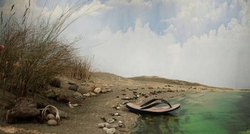 Movie still from “Eagle vs Shark” (2007), directed by Taika Waititi – A pair of flip flops sitting on top of a sandy beach; Extreme Wide shot, High angle