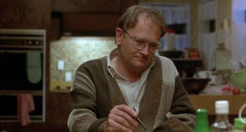 Movie still from “Eagle vs Shark” (2007), directed by Taika Waititi – A man with glasses is writing on a piece of paper; Close Up shot, Low angle