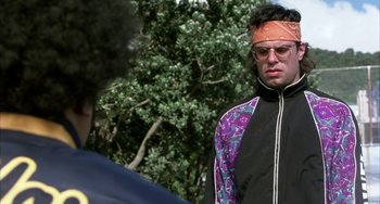 Movie still from “Eagle vs Shark” (2007), directed by Taika Waititi – A man with a bandana around his head and sunglasses on; Close Up shot, Over the shoulder angle